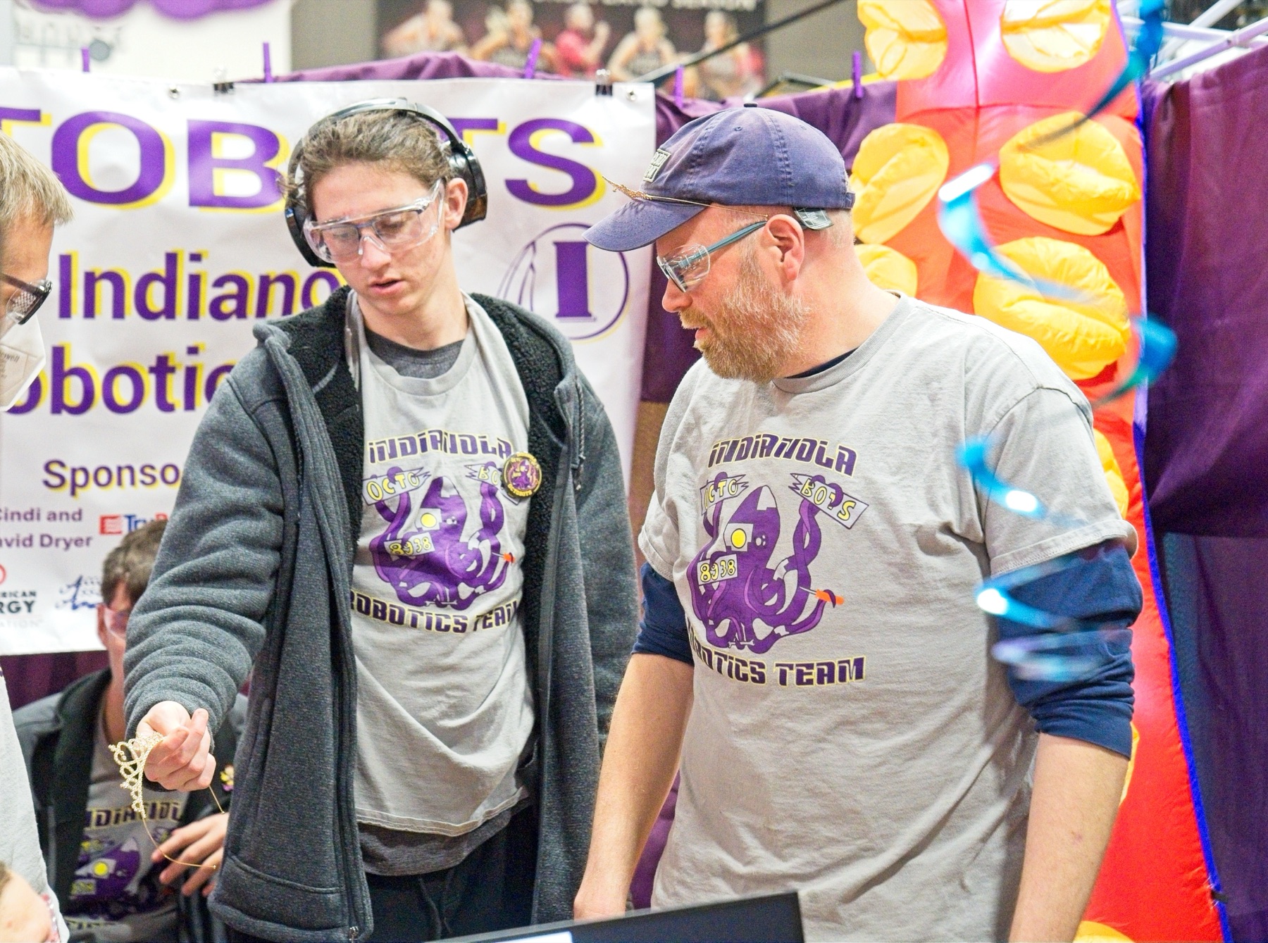 Students and a mentor working on the robot in the pit